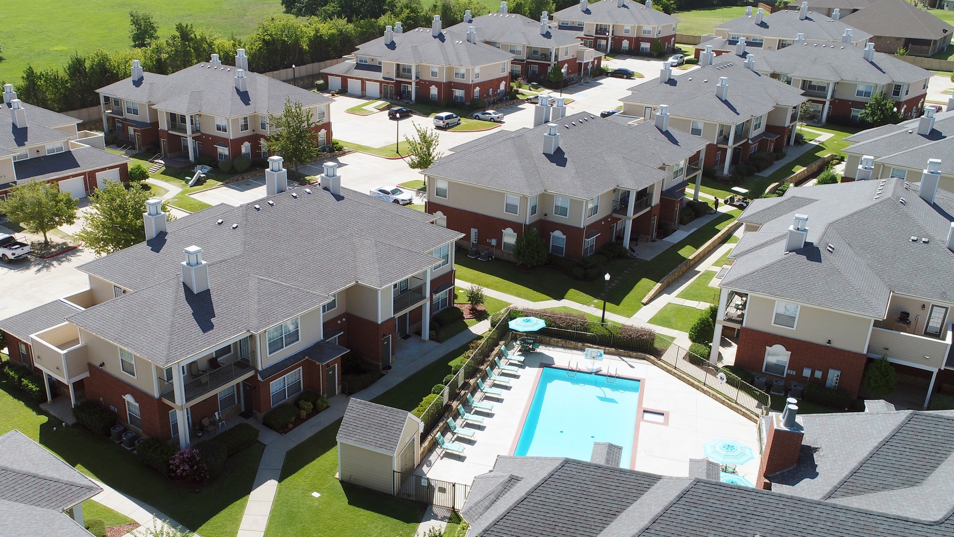 Arial shot of Stone Creek Apartments with manor-like buildings and a pool